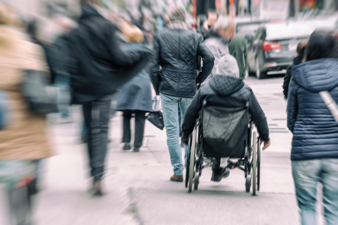 Rollstuhlfahrer in Menschenmenge